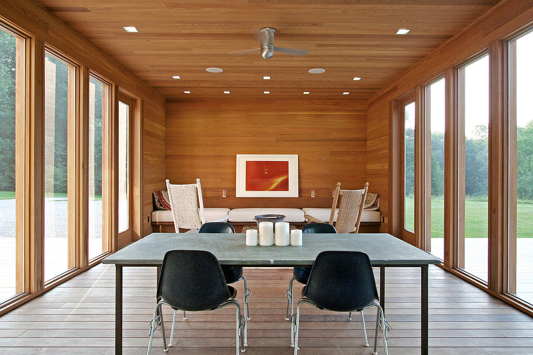 Spacious modern dining room with wooden walls, large windows, and minimalist furnishings.