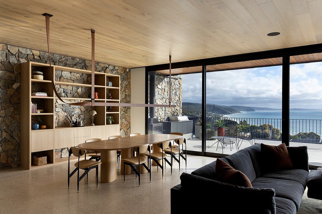 Expansive glass walls, stone accents, and custom wood furnishings highlight the modern, nature-inspired design.