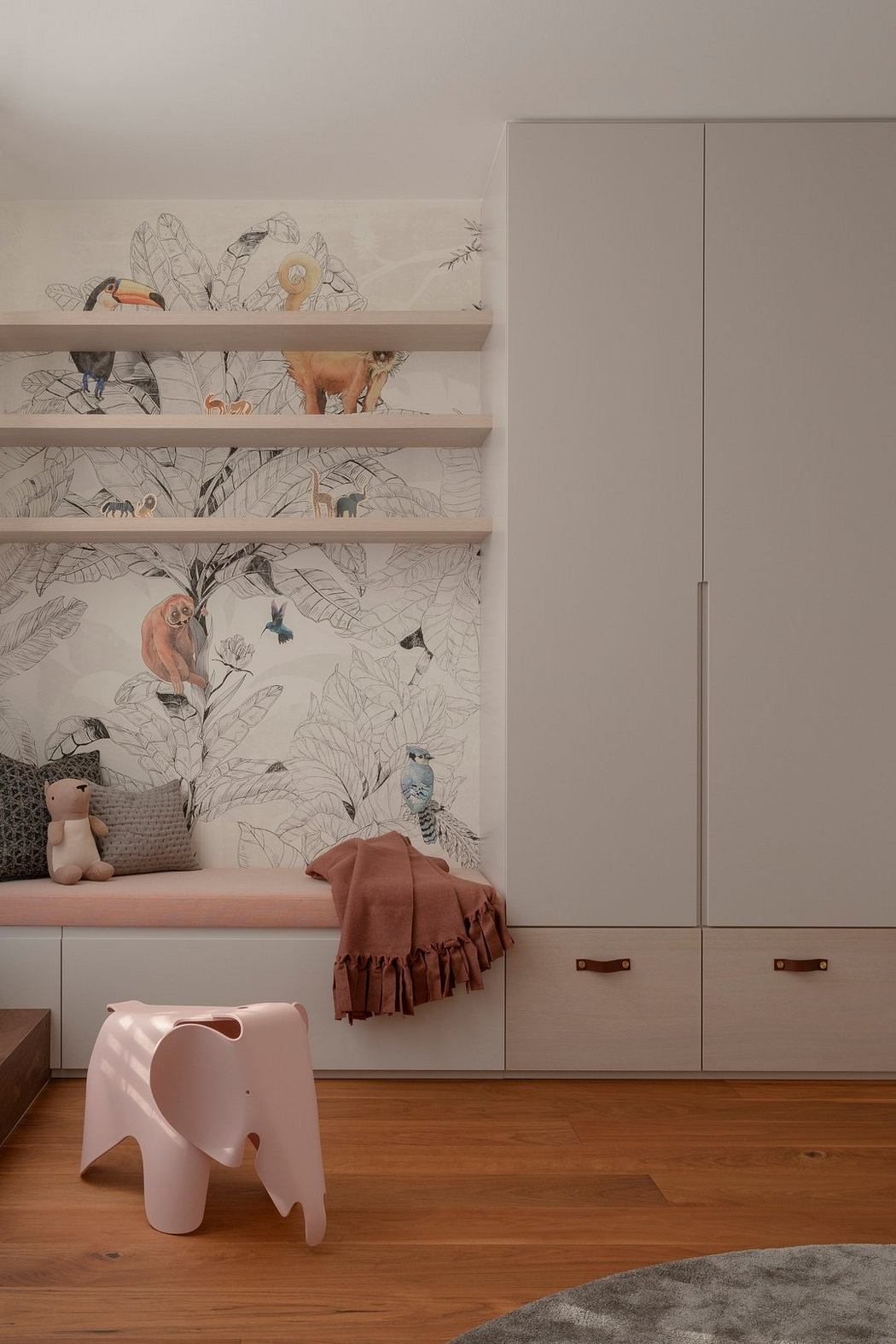 Charming children's room with nature-inspired wallpaper, built-in storage, and playful decor.