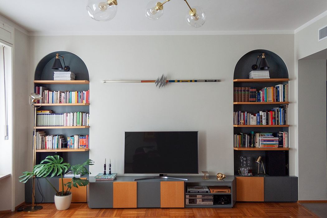 Stylish living room with built-in bookshelves, TV cabinet, and modern lighting fixtures.