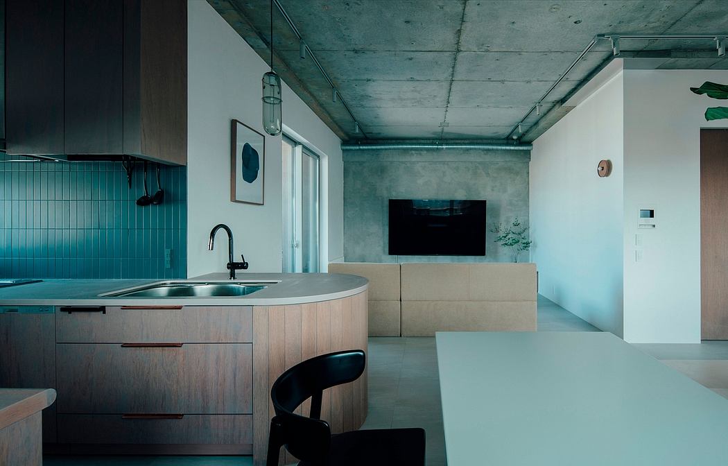 Modern kitchen with concrete ceiling, wood cabinetry, and a minimalist living area.