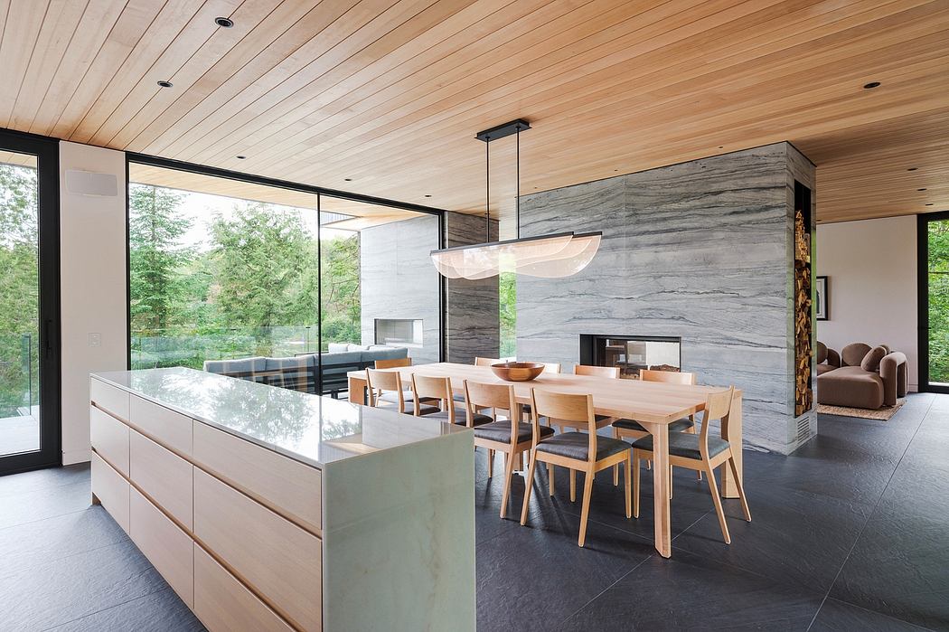 Modern open-plan kitchen and dining room with sleek wood and stone finishes.