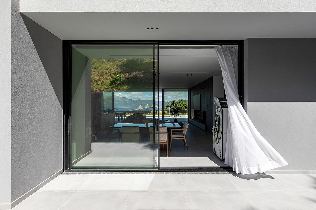 A modern, open-plan interior with floor-to-ceiling windows offering a scenic outdoor view.