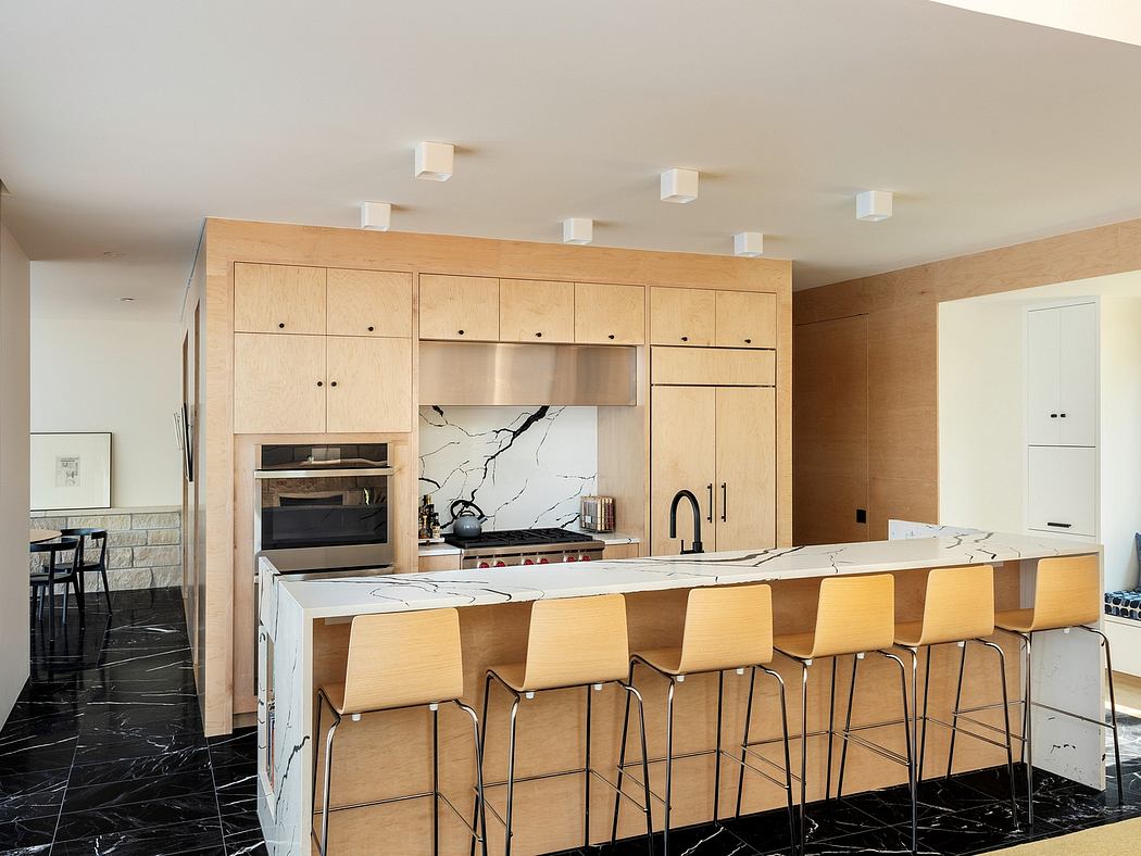Modern kitchen with sleek wood cabinets, marble countertops, and stylish lighting.