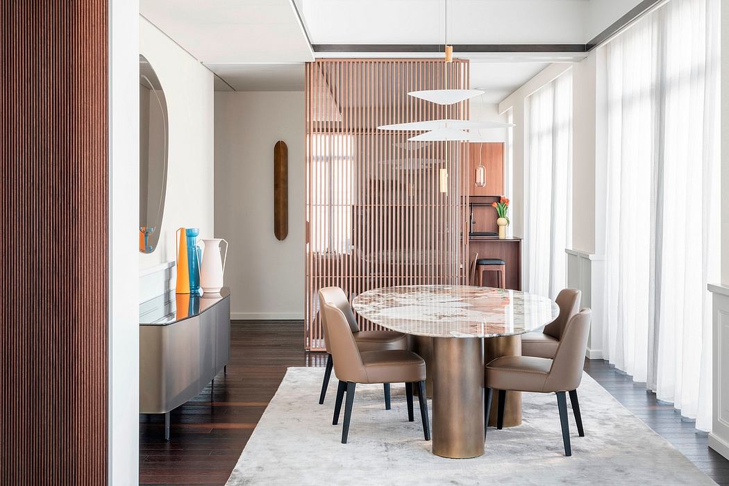Sleek modern dining room with marble table, wood screens, and contemporary lighting.