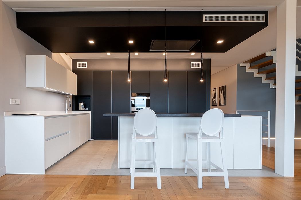 Sleek, contemporary kitchen with black cabinetry, white countertops, and modern lighting.
