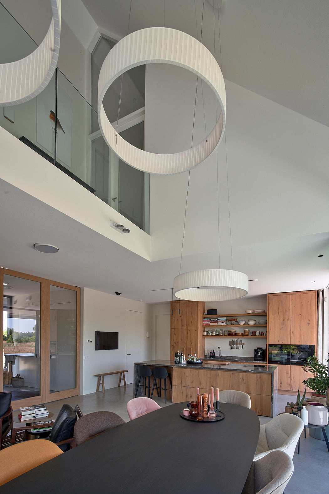 Minimalist yet warm living space with circular light fixtures and wooden cabinetry.