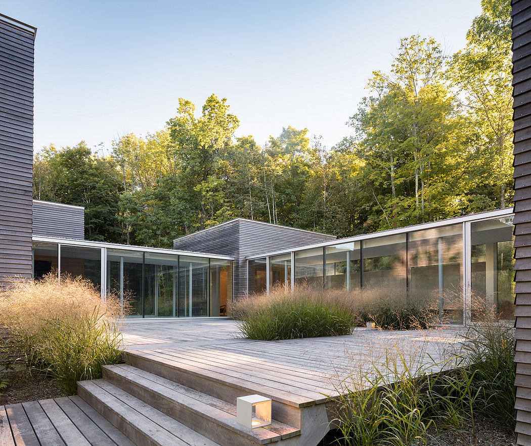A modernist residential structure surrounded by a landscaped deck and lush foliage.