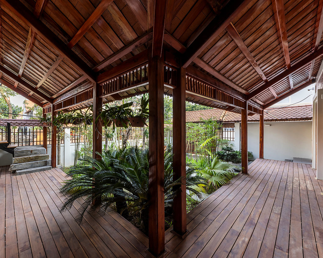 Rustic wooden pavilion with tropical plants and lush greenery surrounding a spacious deck.