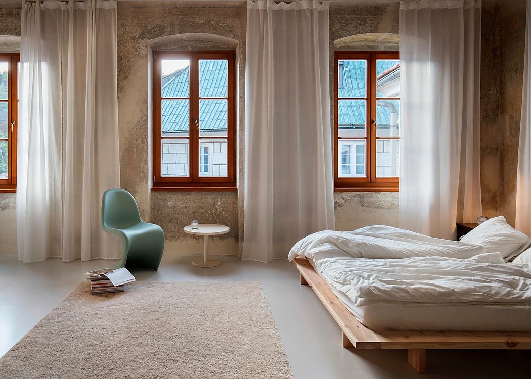 Spacious bedroom with large windows, minimal furnishings, and wood platform bed.