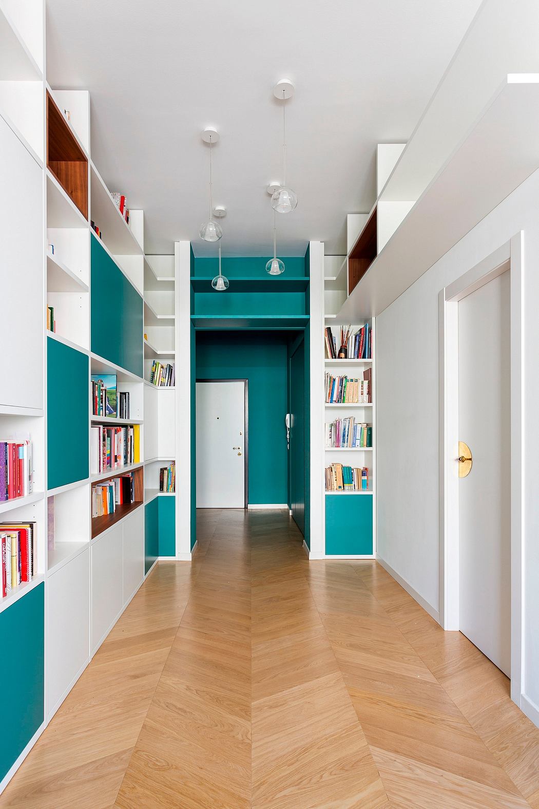 Vibrant teal accents complement the modern, minimalist design and built-in shelving.