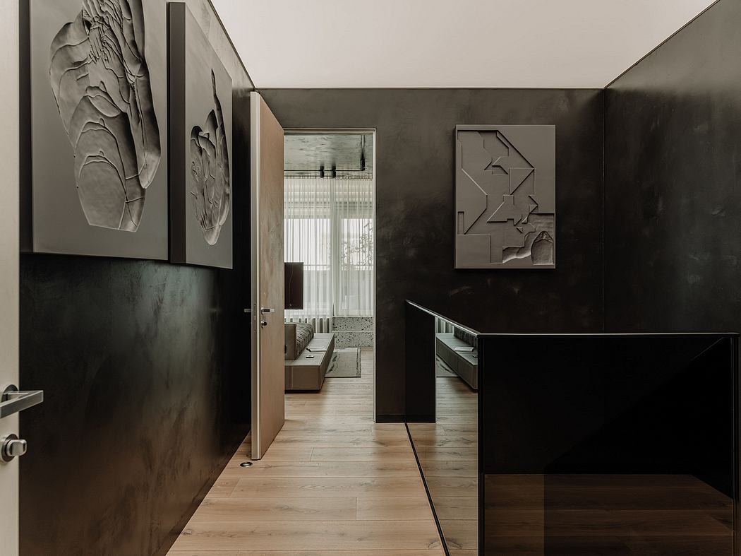 Monochrome hallway with modern geometric art, sleek cabinetry, and natural wood floors.