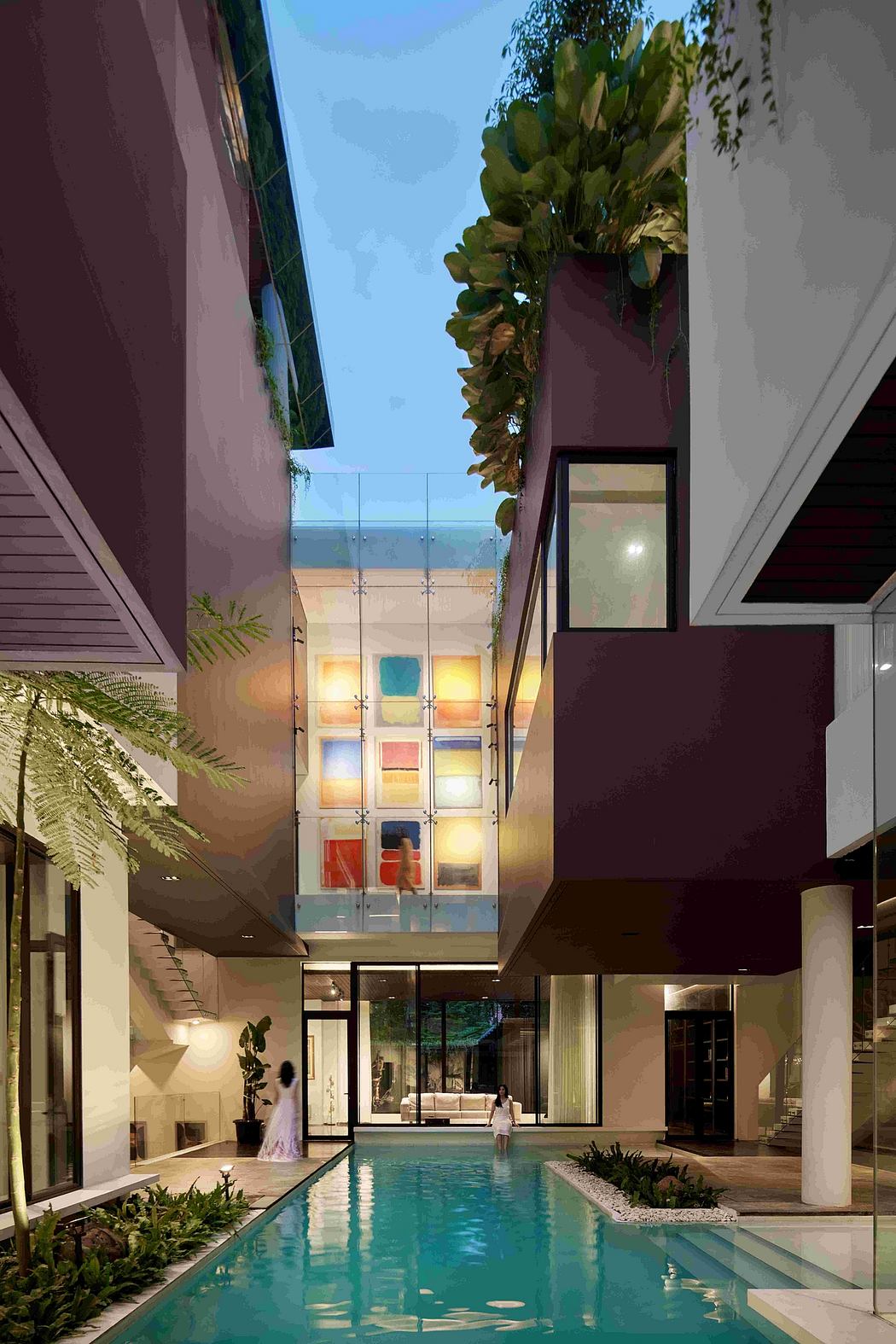 A modern building with a sleek, minimalist design, featuring a vibrant glass facade and a serene pool.