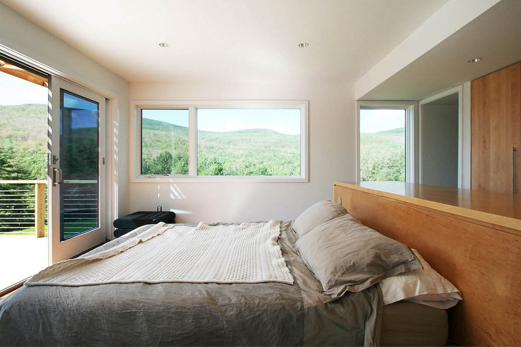Spacious, modern bedroom with large windows offering scenic mountain views and natural light.