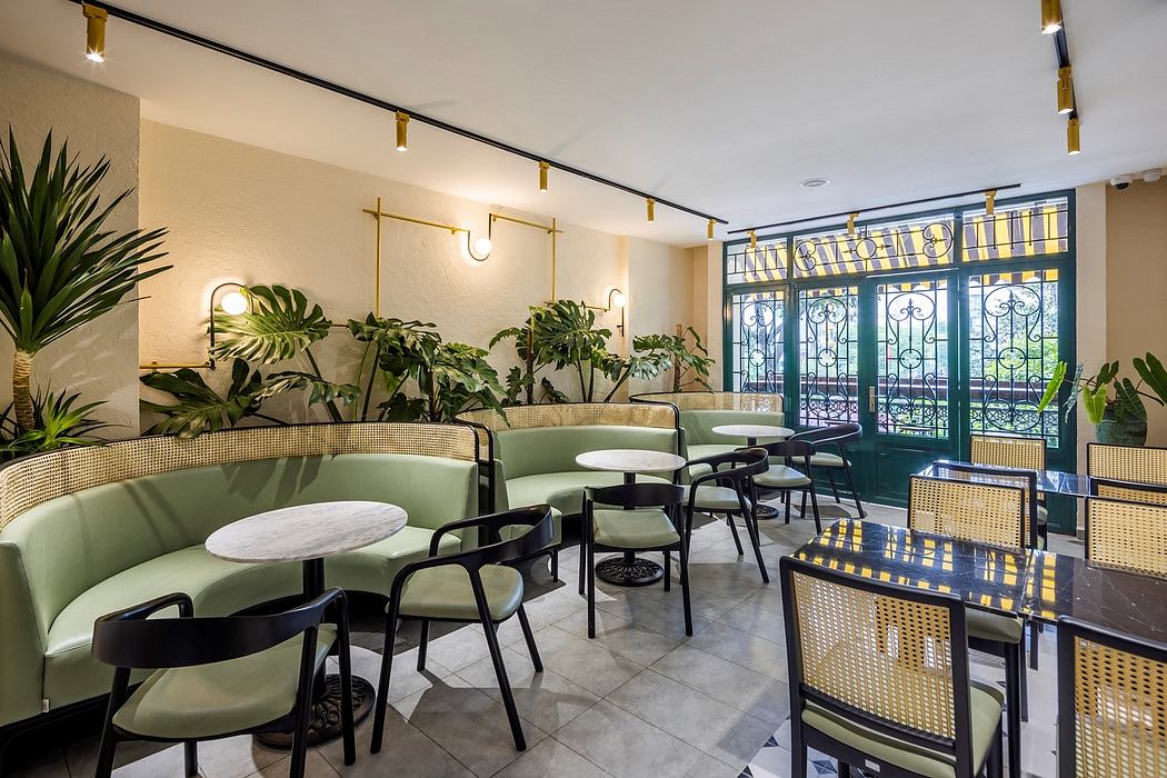 Bright, modern café interior with lush potted plants, metallic accents, and elegant seating.