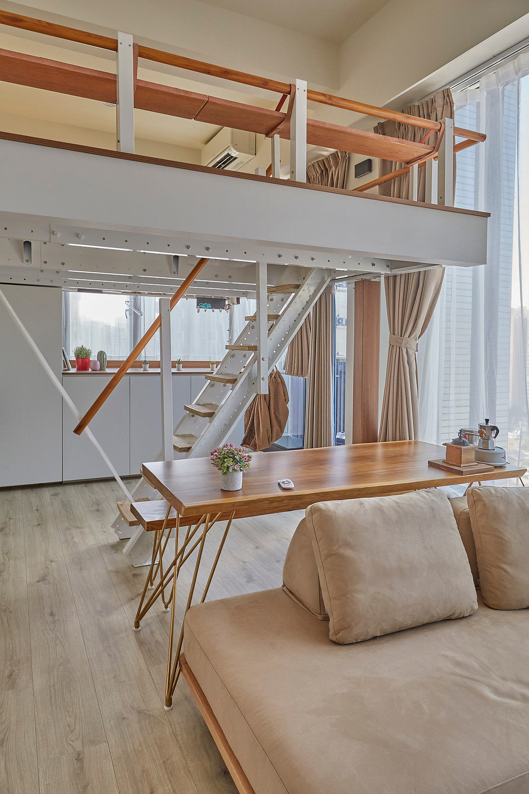 Modern interior with mezzanine, wooden beams, and minimalist furnishings.