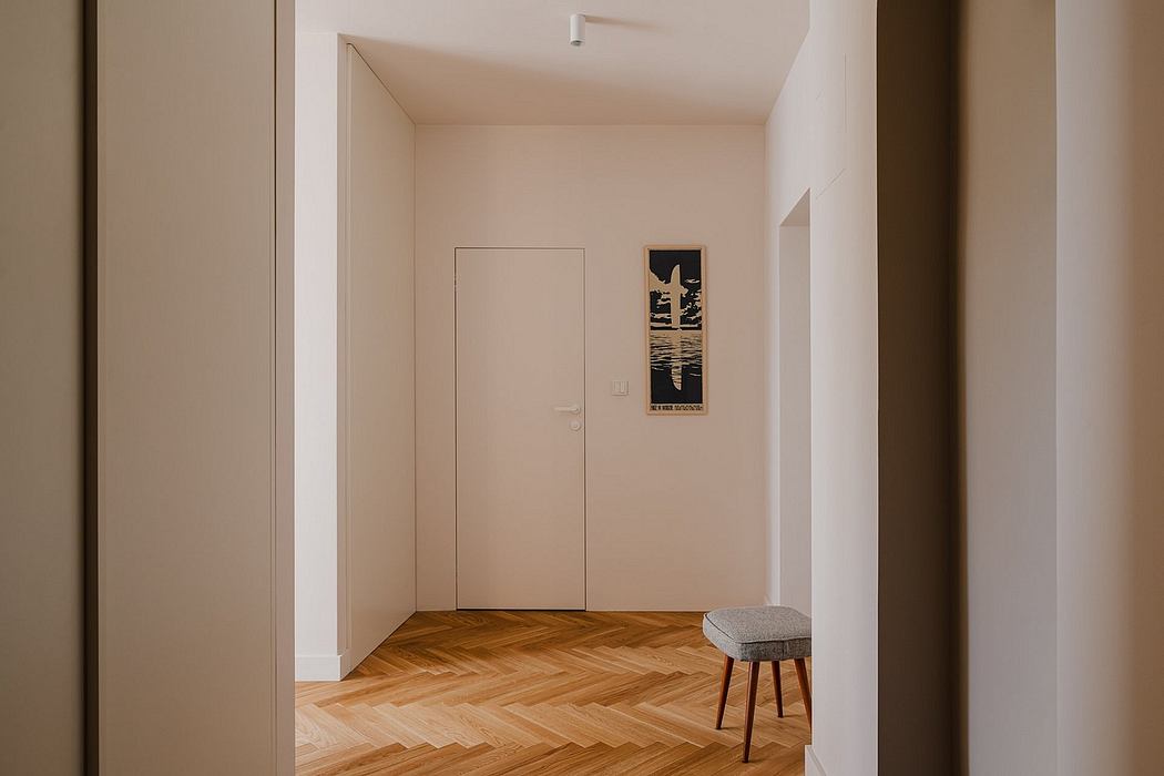 Minimalist hallway with herringbone wood flooring and a framed artwork on the wall.