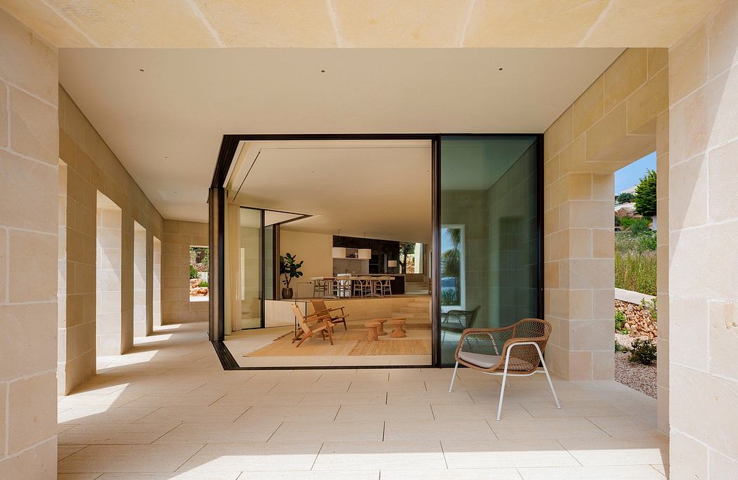 Spacious open-plan living area with large sliding glass doors, stone walls, and modern furnishings.