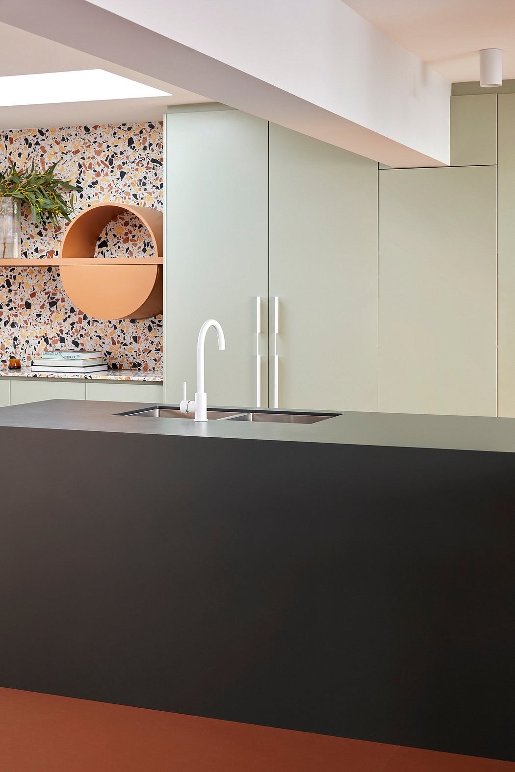 Sleek modern kitchen design with terrazzo backsplash, floating shelves, and dark countertop.