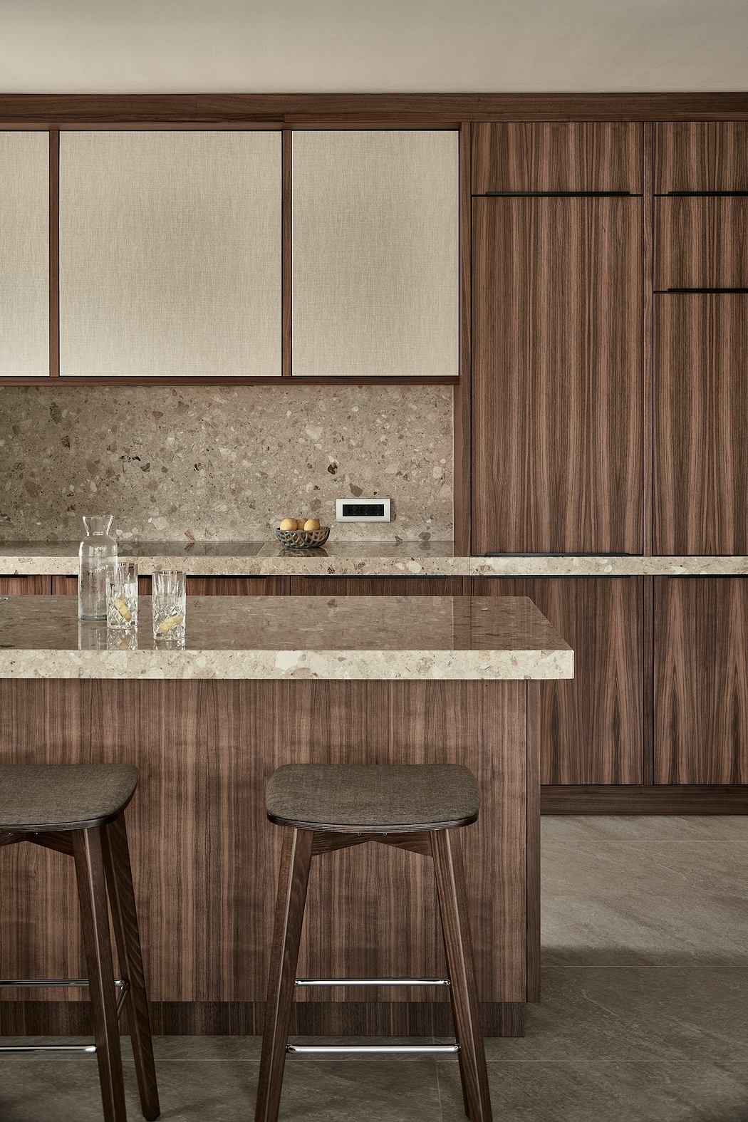 Modern kitchen with wood panels, stone countertop, and minimalist bar stools.