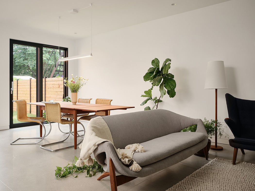 Cozy living space with elegant wood furnishings, modern lighting, and lush greenery.