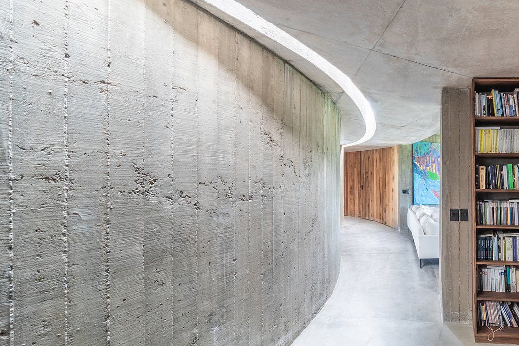 Striking concrete walls, curved ceiling, and wooden accents in modern interior.