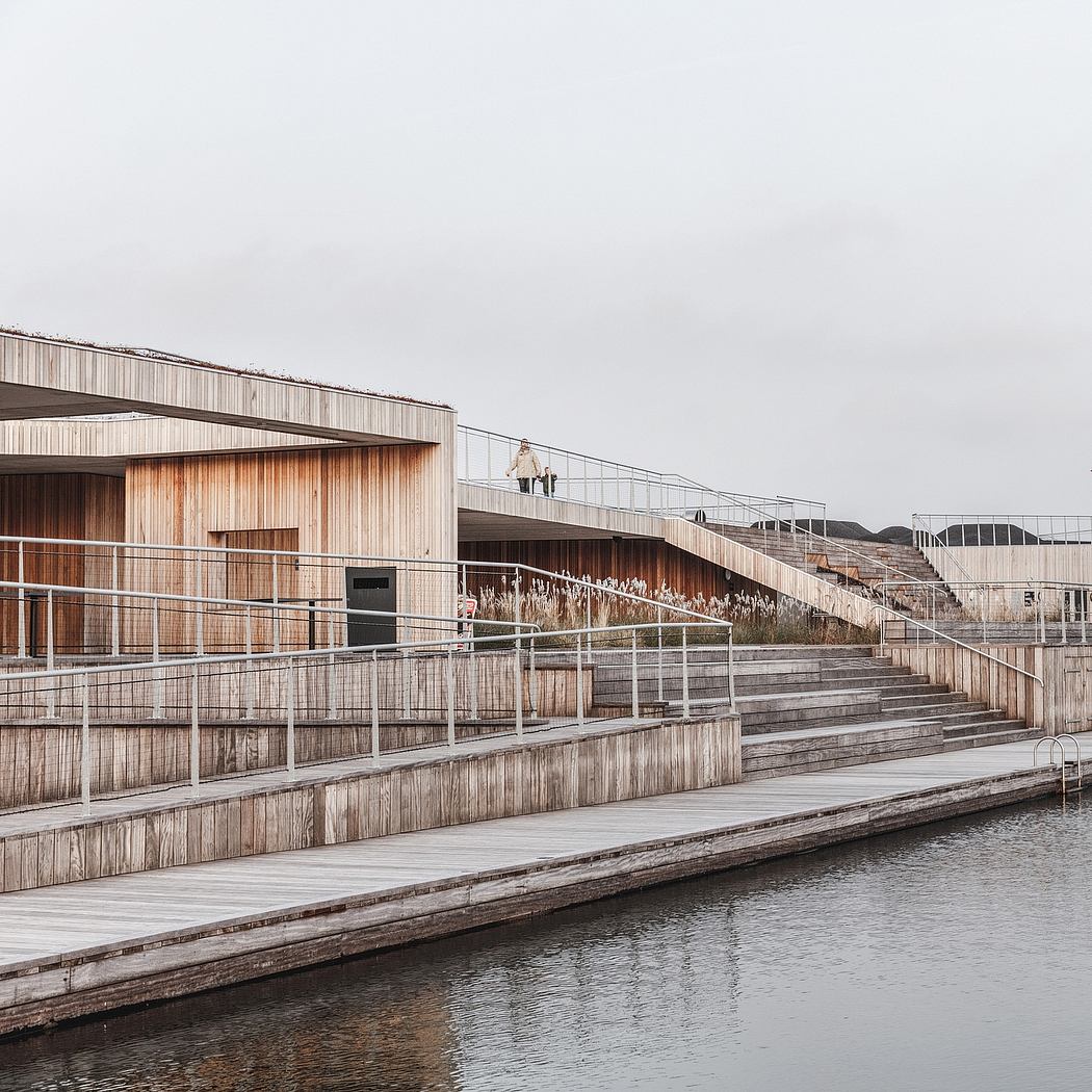 Wooden architectural structure with tiered steps and railings overlooking a body of water.