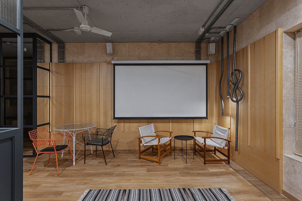 A modern home theater with a wooden-paneled wall, a large projection screen, and minimalist furniture.