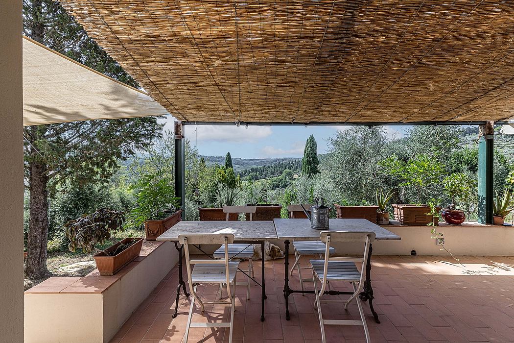 Rustic patio with wooden pergola, outdoor dining area, and scenic countryside view.