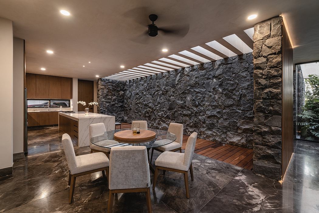 Sleek, modern kitchen and dining area with stone walls, wooden floors, and pendant lighting.