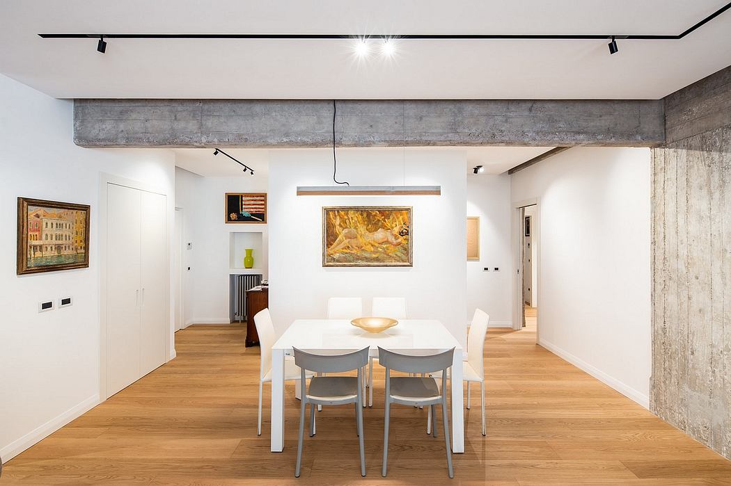 Spacious, minimalist loft-style interior with concrete walls, wood floors, and modern furnishings.