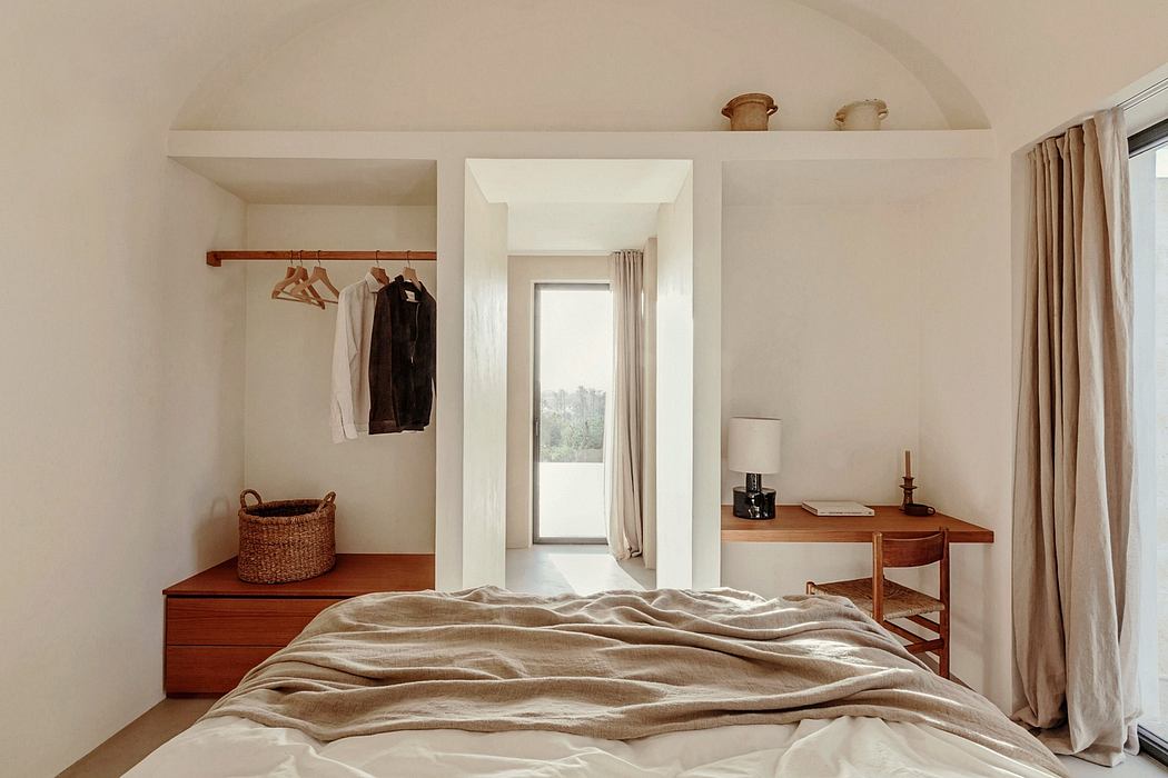 Cozy bedroom with warm wooden furnishings, neutral color scheme, and a view through the doorway.
