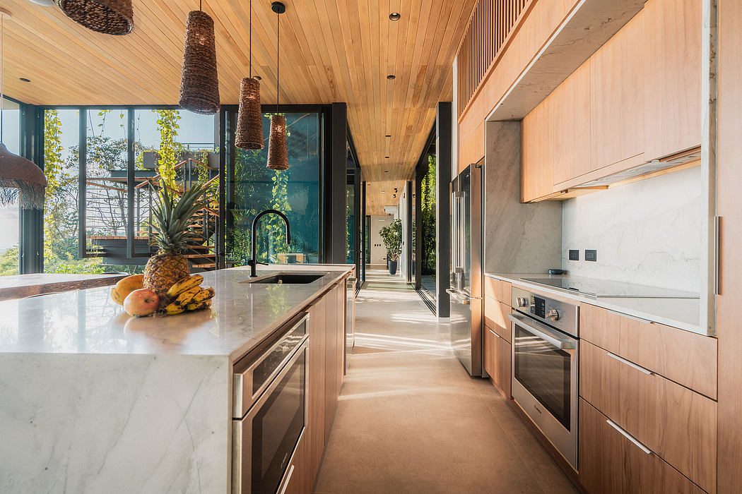 Spacious kitchen with modern wood paneling, marble countertops, and overhead lighting fixtures.