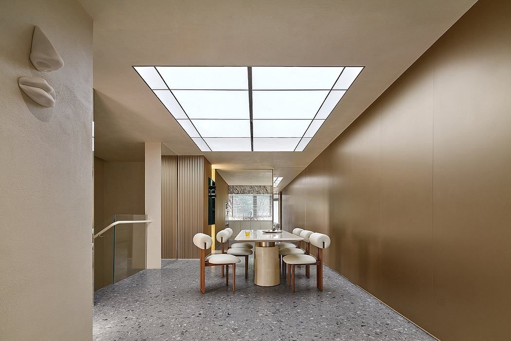 The image showcases a modern, minimalist dining area with a large skylight, sleek furniture, and a terrazzo floor.