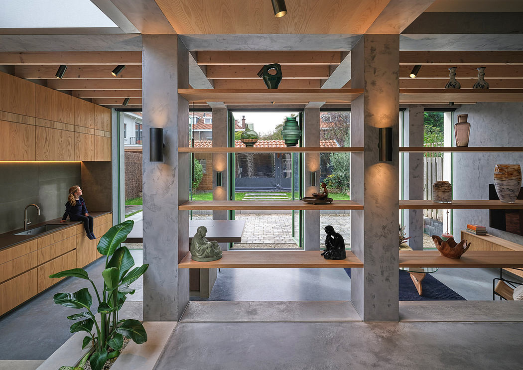 Expansive modern interior with wood and concrete accents, shelves, and garden view.