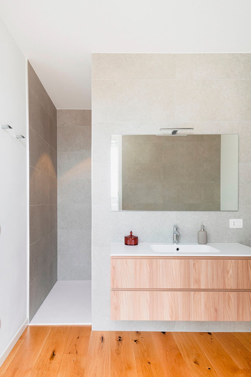 Modern bathroom with minimalist design, wood vanity, and large mirror.