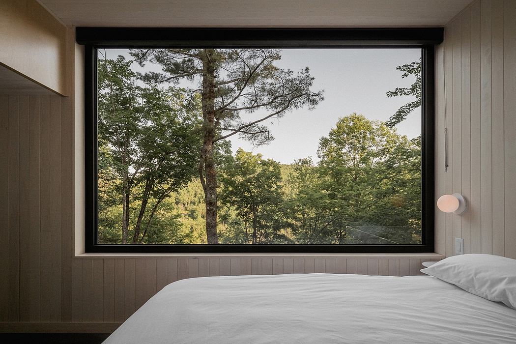 Panoramic window frame with lush forest view, simple modern bedroom design.