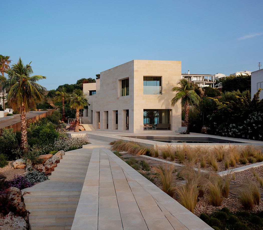 A modern, minimalist residence with clean lines, large windows, and a manicured landscape.