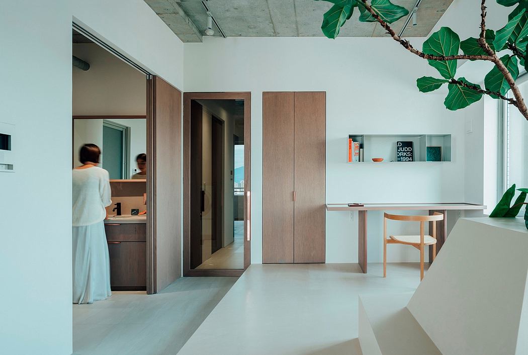 Minimalist interior with wooden accents, built-in storage, and natural greenery.