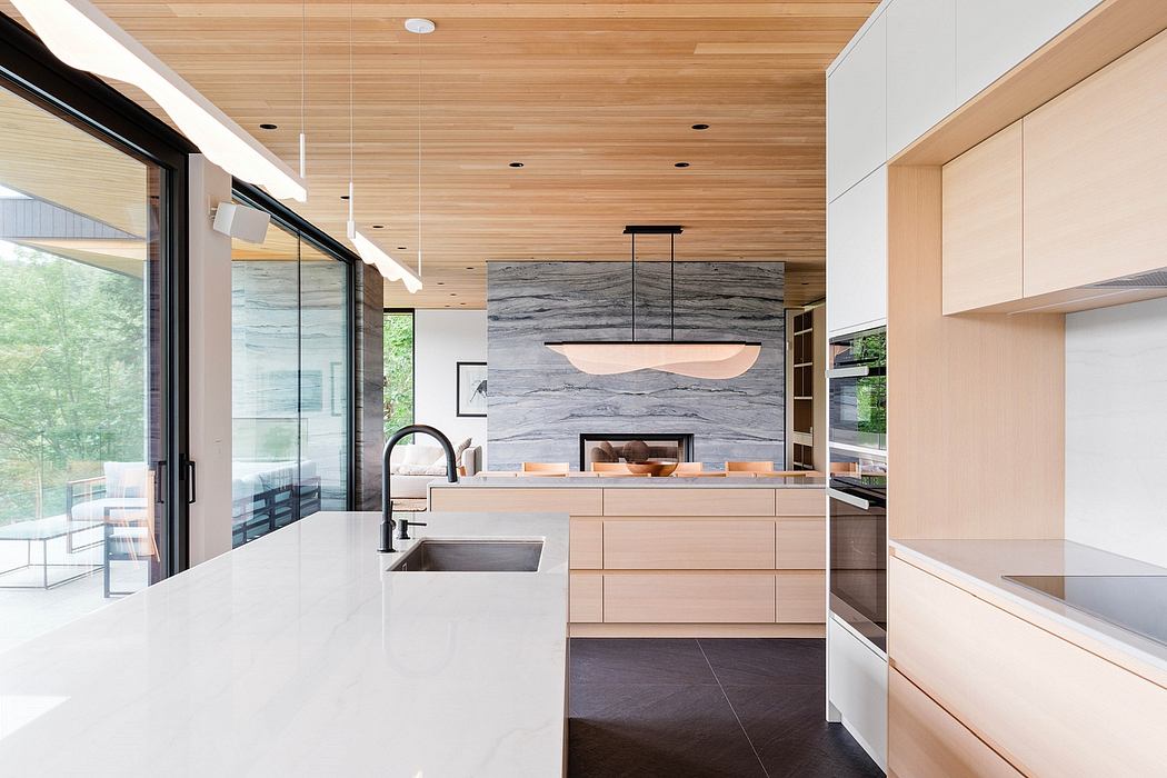 Minimalist kitchen with wood ceiling, marble backsplash, and sleek cabinets.