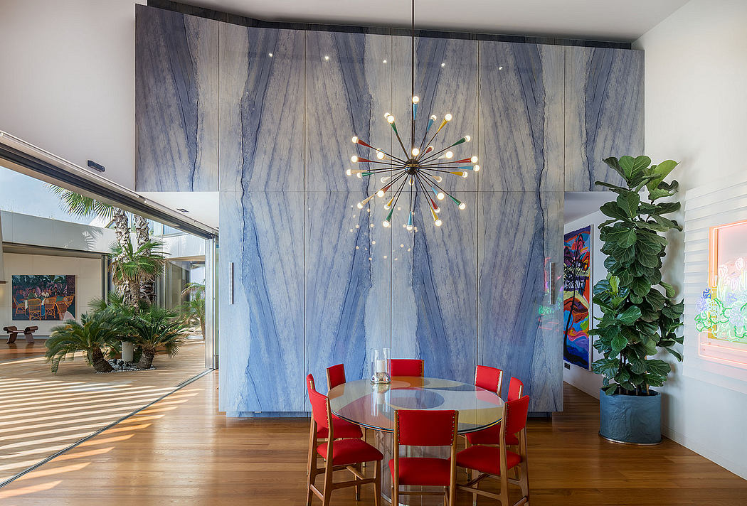 Elegant dining area with marble-patterned wall panels and a modern, ornate chandelier.