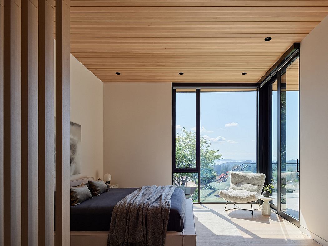 Cozy modern bedroom with floor-to-ceiling windows, wooden ceiling, and comfortable chair.
