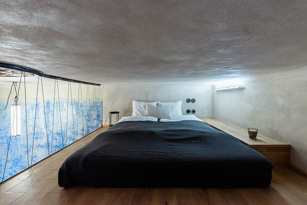 Minimalist bedroom with modern lighting fixtures, textured walls, and a large bedframe.