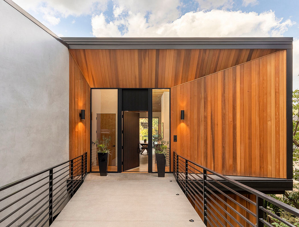 A modern, wooden-paneled entry with sleek black framing and recessed lighting.