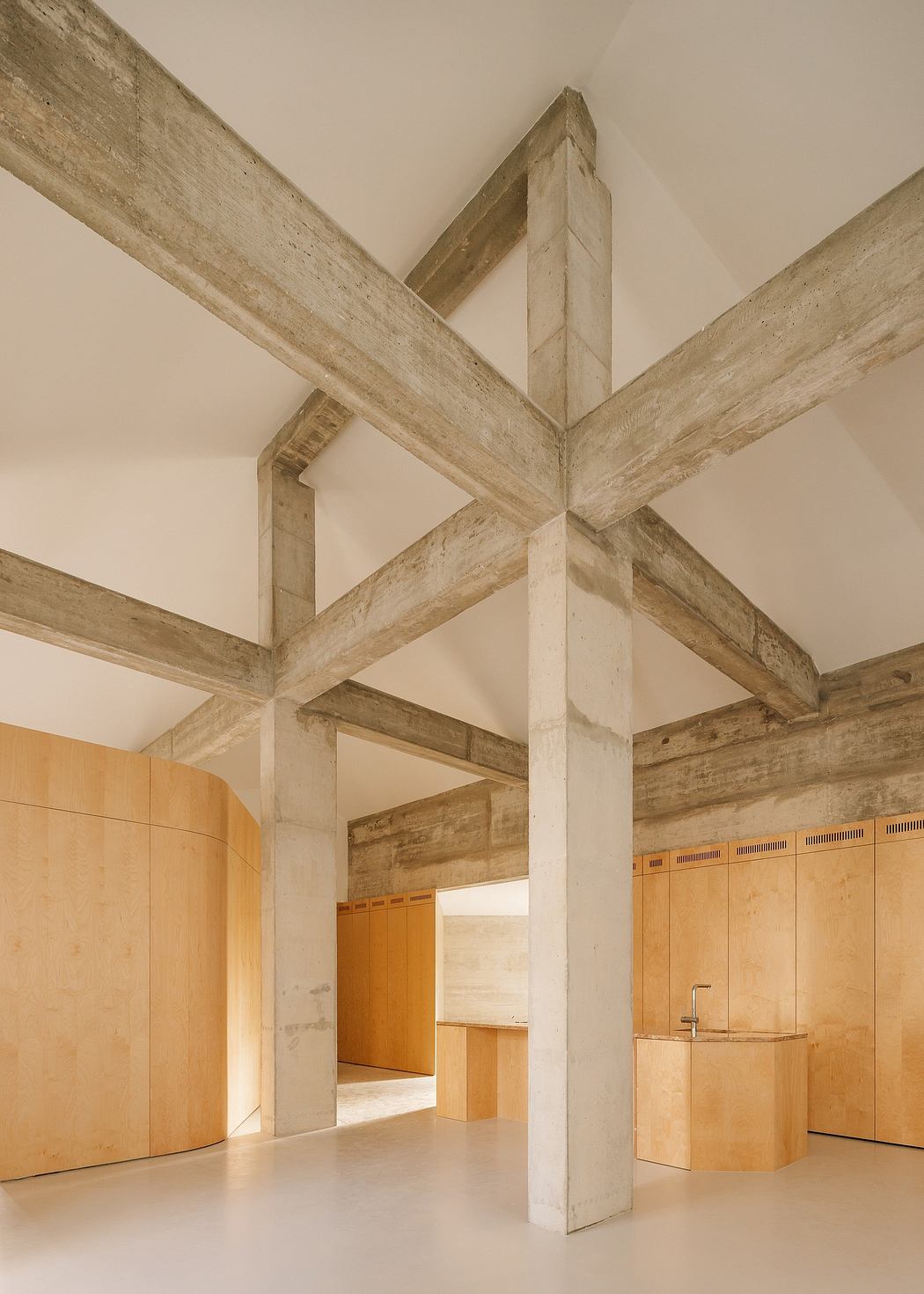 Striking wooden beams, geometric patterns, and warm wood tones create a modern, minimalist space.