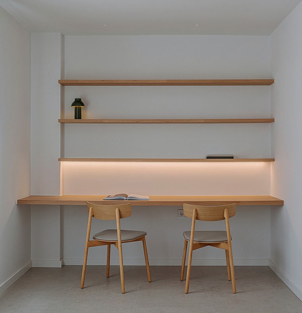 Minimal workspace with wooden shelves, table, and chairs in a bright, minimalist room.