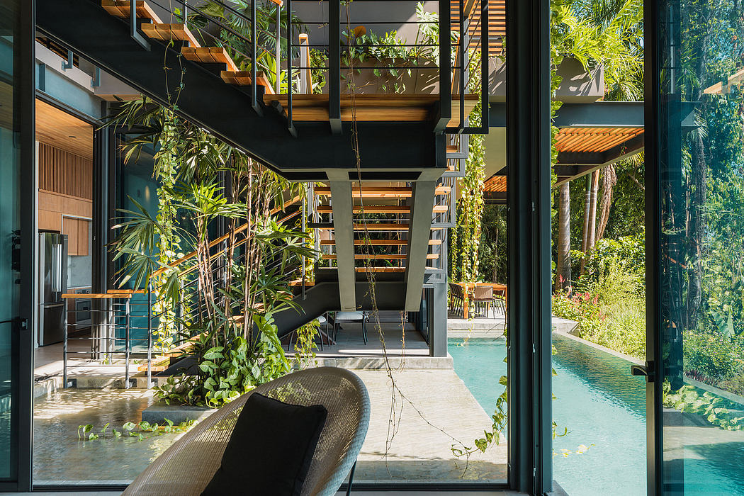 Striking modern architecture with lush tropical foliage, glass walls, and a tranquil pool.