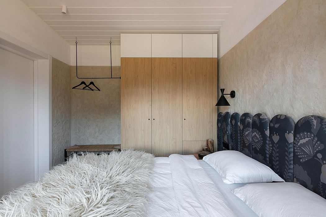 Cozy bedroom with rustic wooden cabinetry, plush white bedding, and striking black and white artwork.