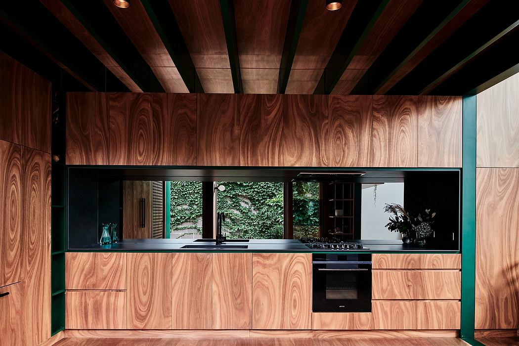 A modern kitchen with a sleek, minimalist design featuring dark wood panels and integrated appliances.