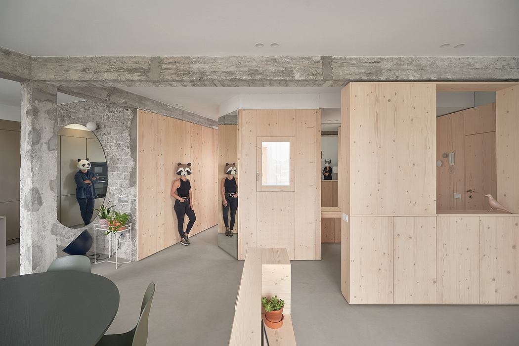 Minimalist loft-style space with exposed concrete walls, wooden panels, and modern furnishings.